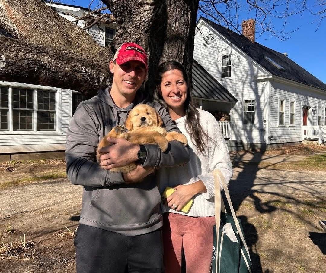 Family snuggling two golden retrievers